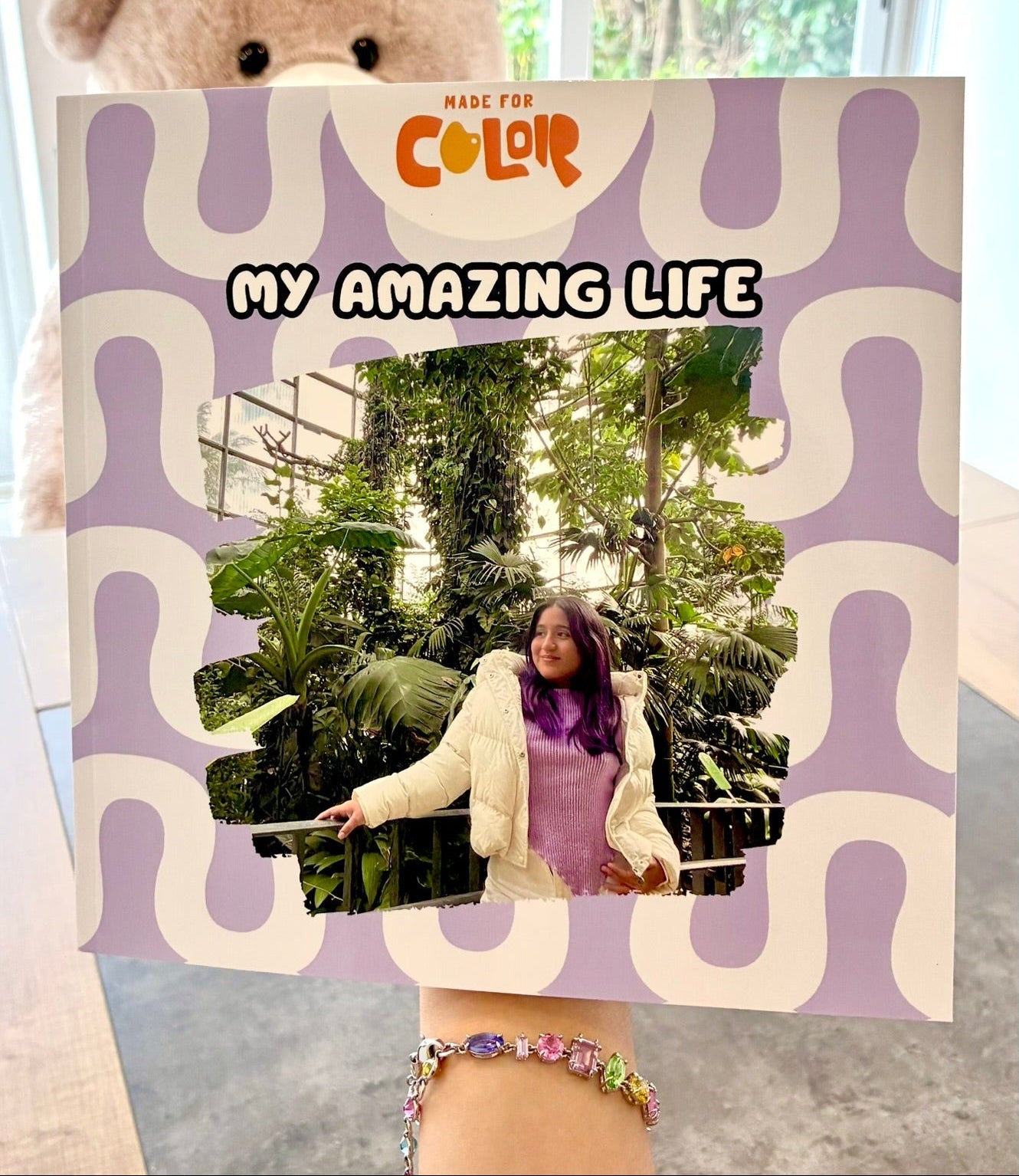 Person holding a coloring book titled 'My Amazing Life'.